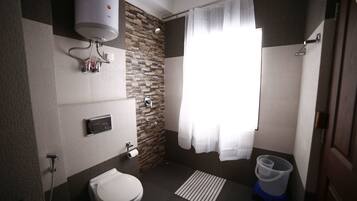 A modern bathroom with a toilet, shower, and a water heater mounted on the wall.