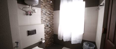 A modern bathroom with a toilet, shower, and a water heater mounted on the wall.