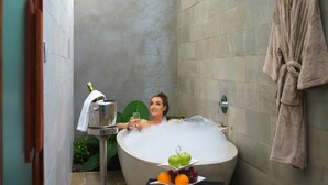 A person relaxing in a bathtub with a fruit tray and a bottle of champagne. - Gold Smith Residence (Siem Reap)