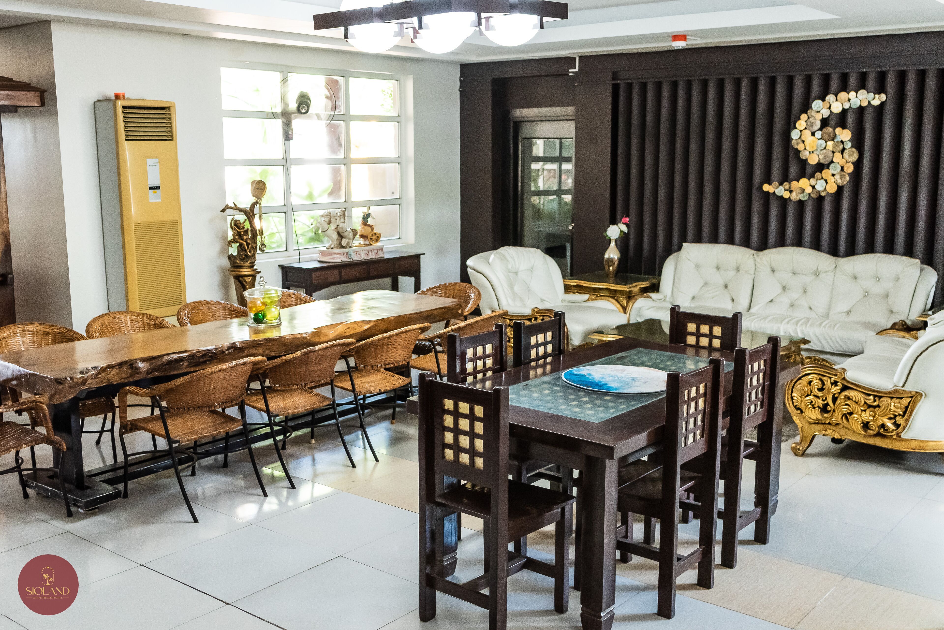 Un comedor con una mesa y sillas de madera, un sofá blanco y un adorno en la pared.
