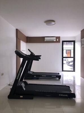 A room with two treadmills, a white ceiling, and a door leading outside. - Quezon Premier Hotel Lucena (Lucena)
