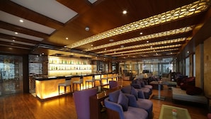 Un espace bar moderne avec un plafond en bois et un comptoir de bar doté de sièges.