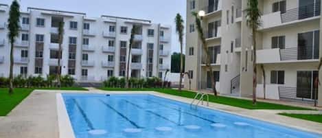 Alberca al aire libre, sombrillas en la alberca y camastros