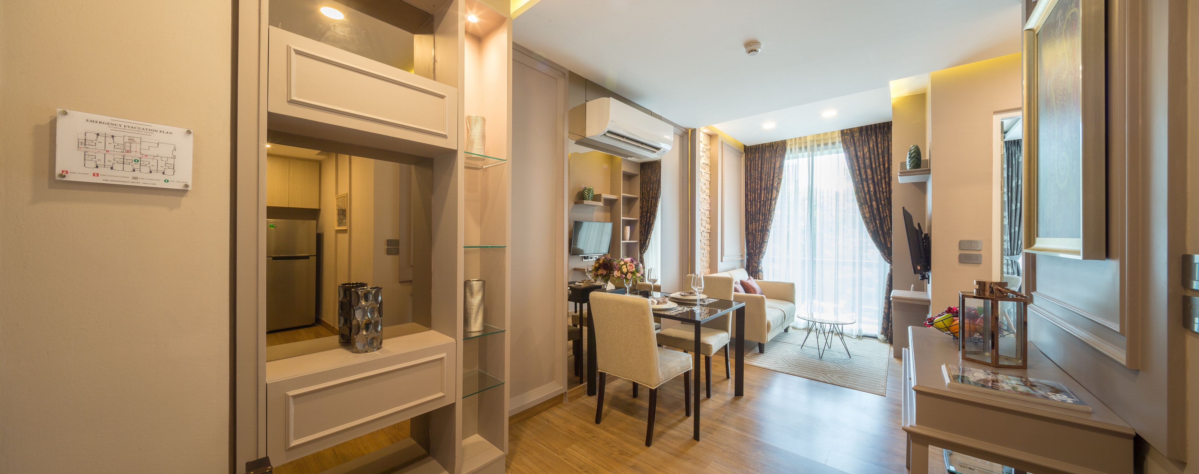 Quarto de hotel moderno com área de refeições, cozinha compacta e sala de estar.