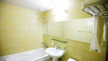 A bathroom with a bathtub, sink, and toilet. There is a mirror above the sink and a towel rack on the wall.