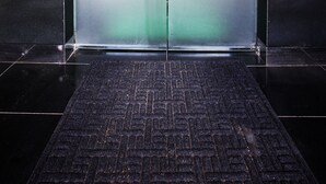 An elevator with a frosted glass door featuring a logo and the word "HOTEL" in the center. - Q Hotel (Paju)