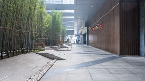 A modern corridor with a bamboo garden, a wooden wall, and a red circular decoration. - Enjoy Stay YUNWEI Apartment (Chengdu)