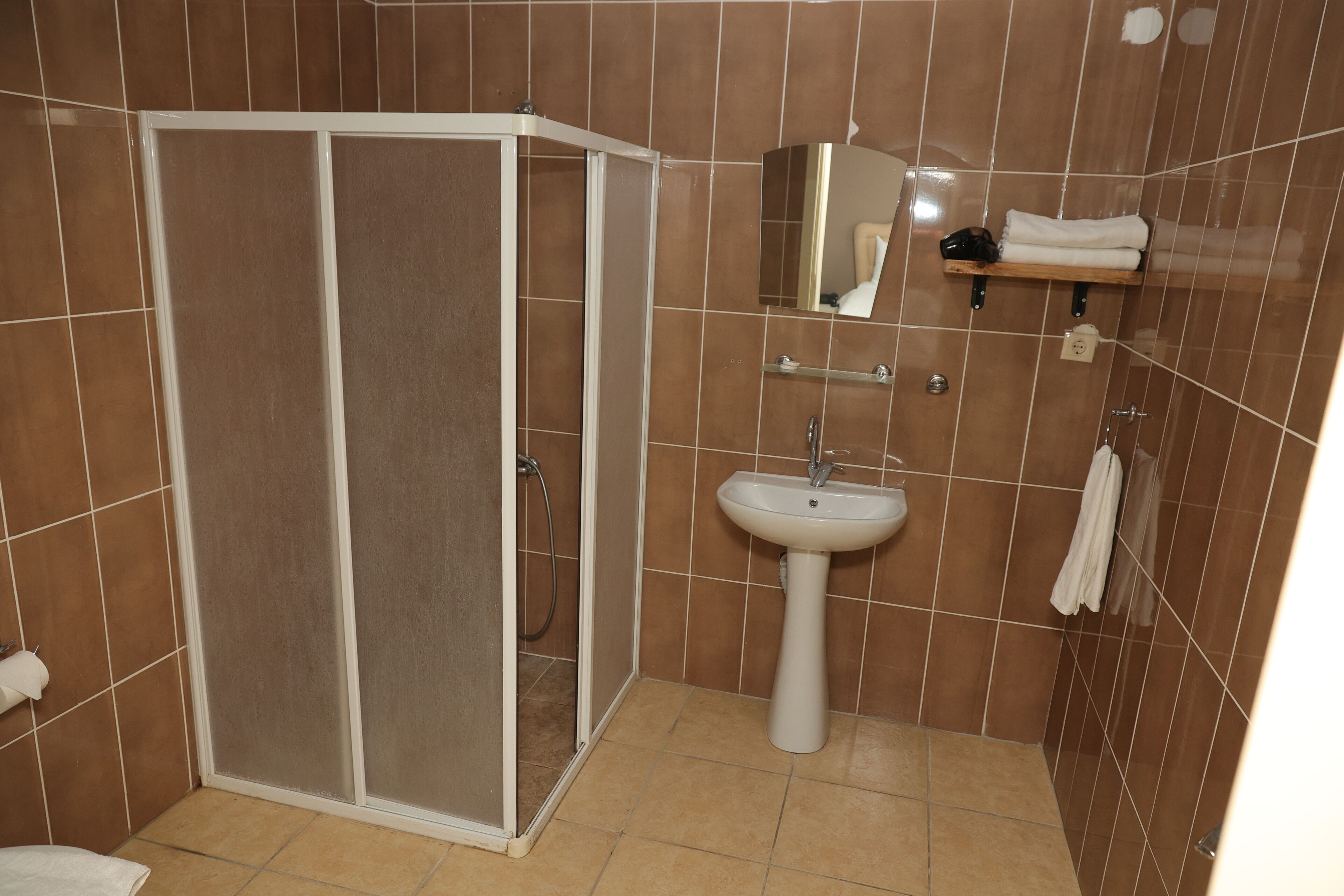 A bathroom with a shower, sink, and towel rack.