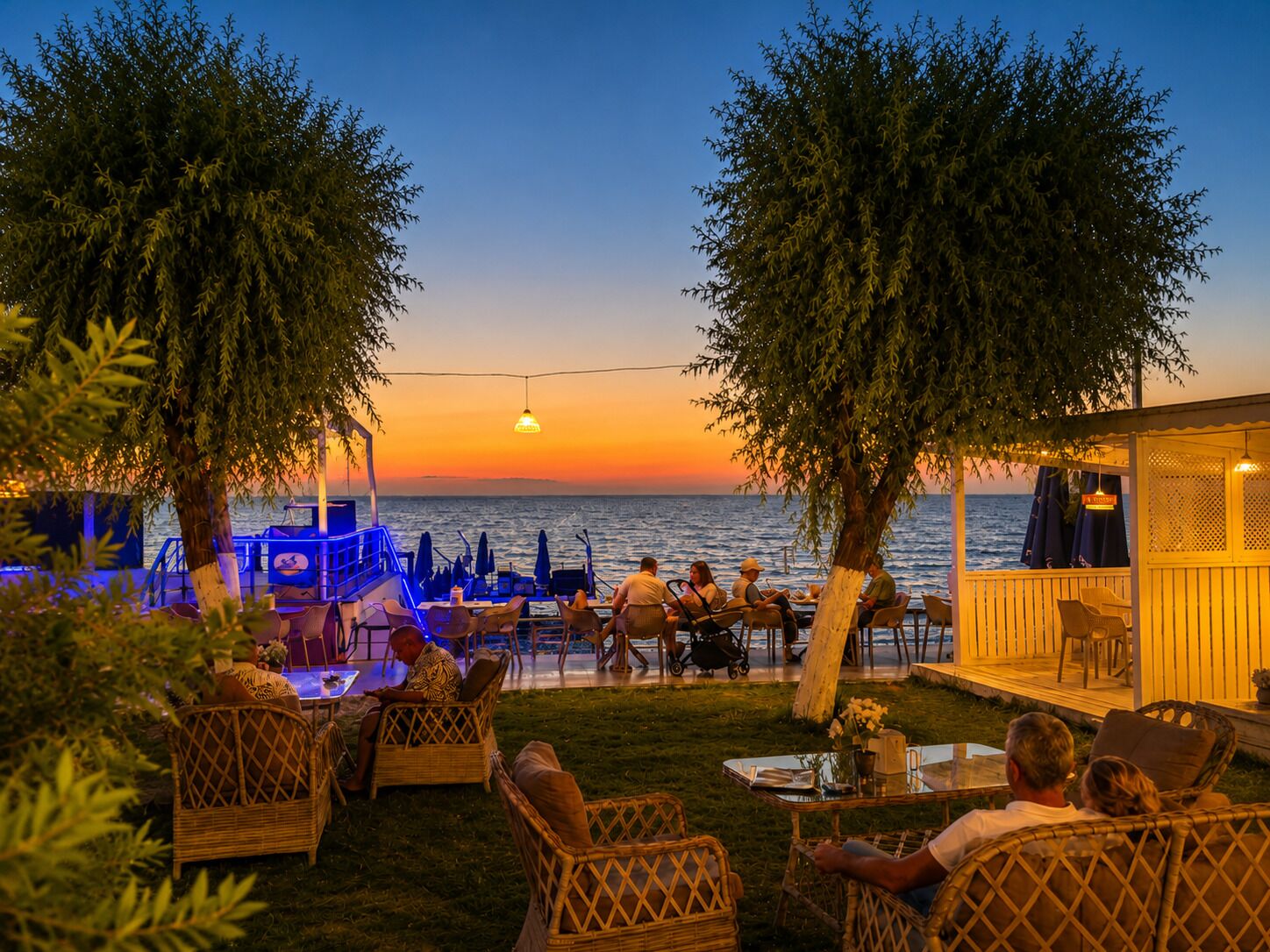 An outdoor seating area with tables and chairs, overlooking a body of water.