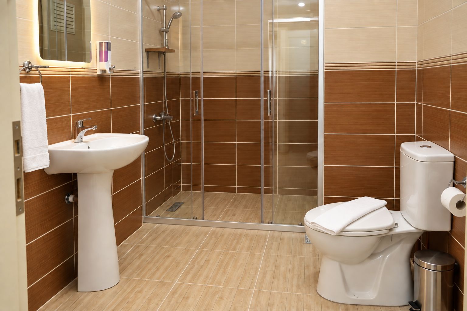 A bathroom with a glass-enclosed shower, a sink, and a toilet.