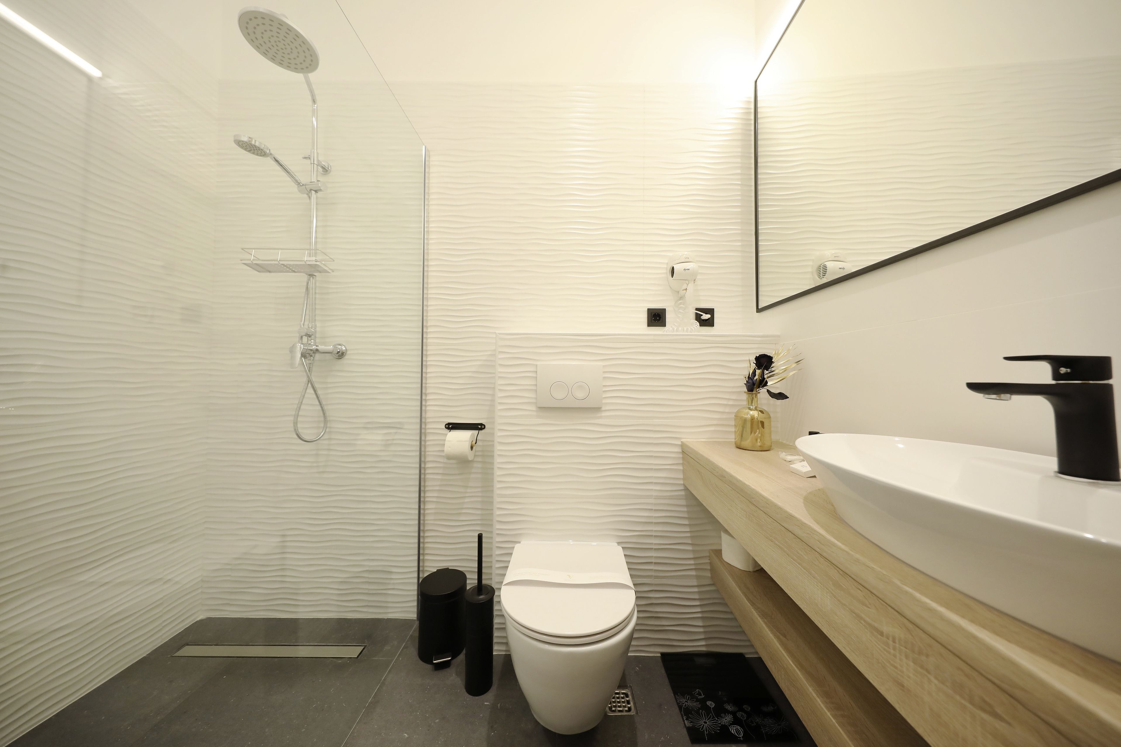 A modern bathroom with a shower, toilet, and sink.