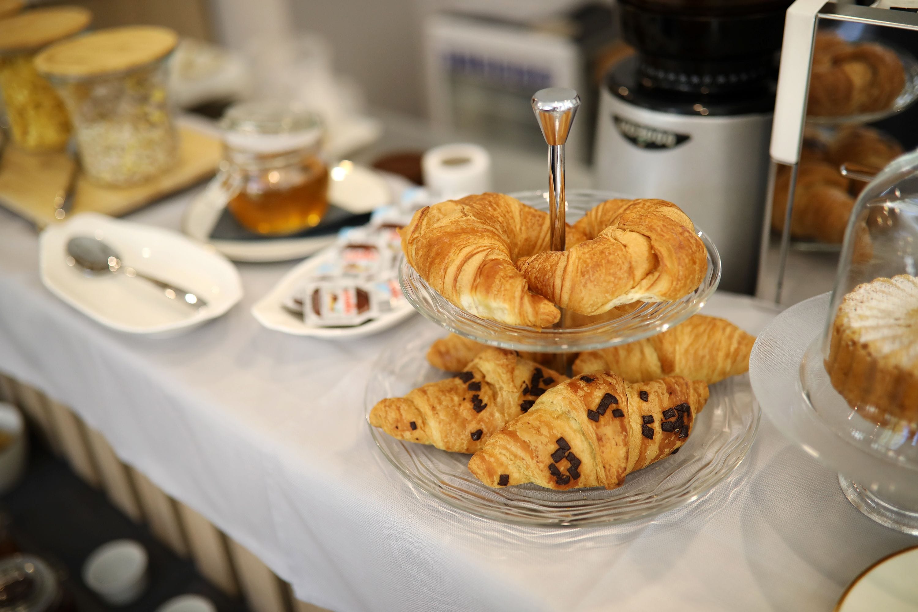 Un bufé de desayuno con cruasanes y pasteles a la vista.