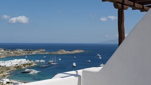 A coastal view with boats, a clear sky, and a white building. - Villa Ammonite (Mykonos)