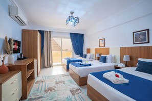 A hotel room with two beds, a desk, a TV, and a large window with a view.