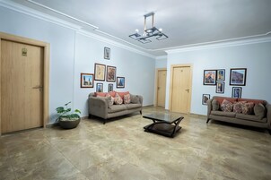A spacious living room with two sofas, a coffee table, and a potted plant.