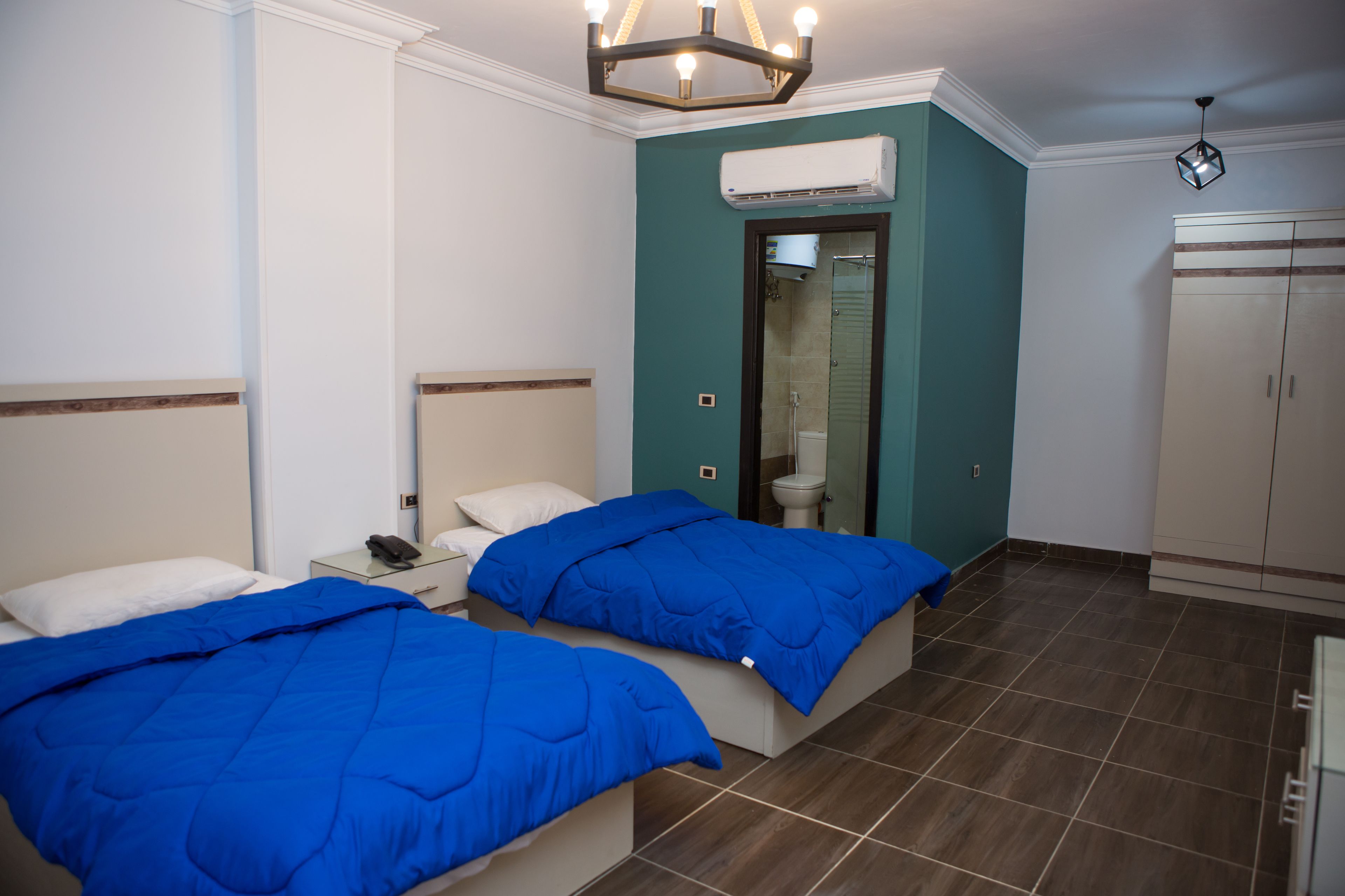 Ein Hotelzimmer mit zwei Betten, einem Badezimmer und einem Kleiderschrank.