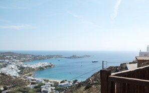 A coastal town with white buildings, a beach, and boats in the water. - Villa Azurite (Mykonos)