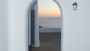Un arco de entrada que da a una vista de la playa al atardecer.