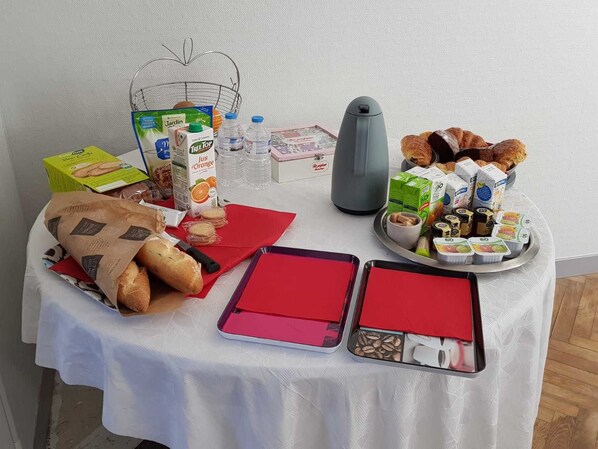 A breakfast table with bread, pastries, milk, juice, and coffee. - Hameau des Essarts (Grand-Couronne)