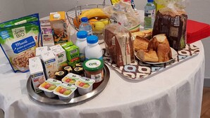 Uma mesa com diversos alimentos, incluindo pão, laticínios e produtos embalados.