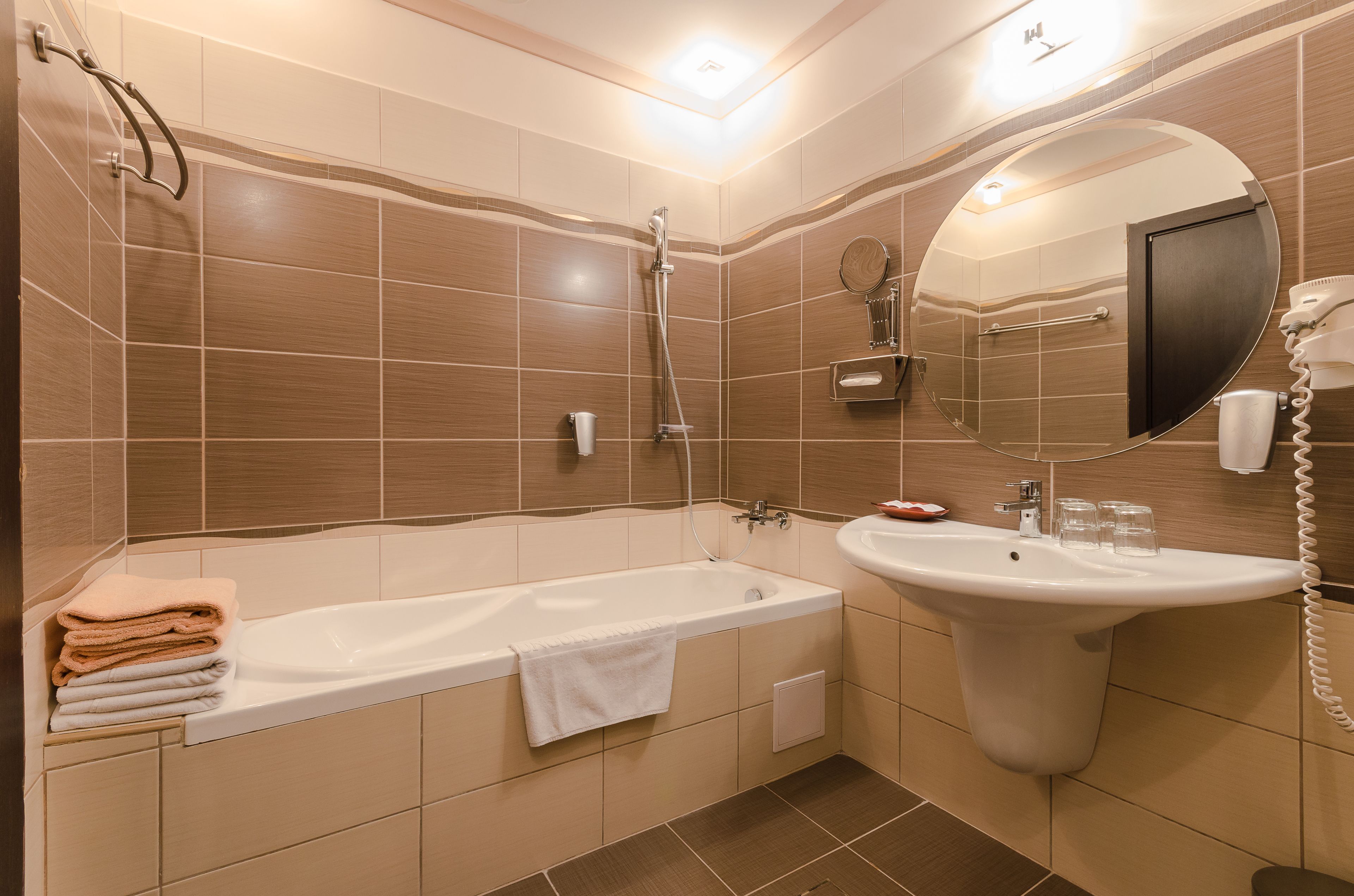 Un baño moderno con bañera, lavamanos y espejo.