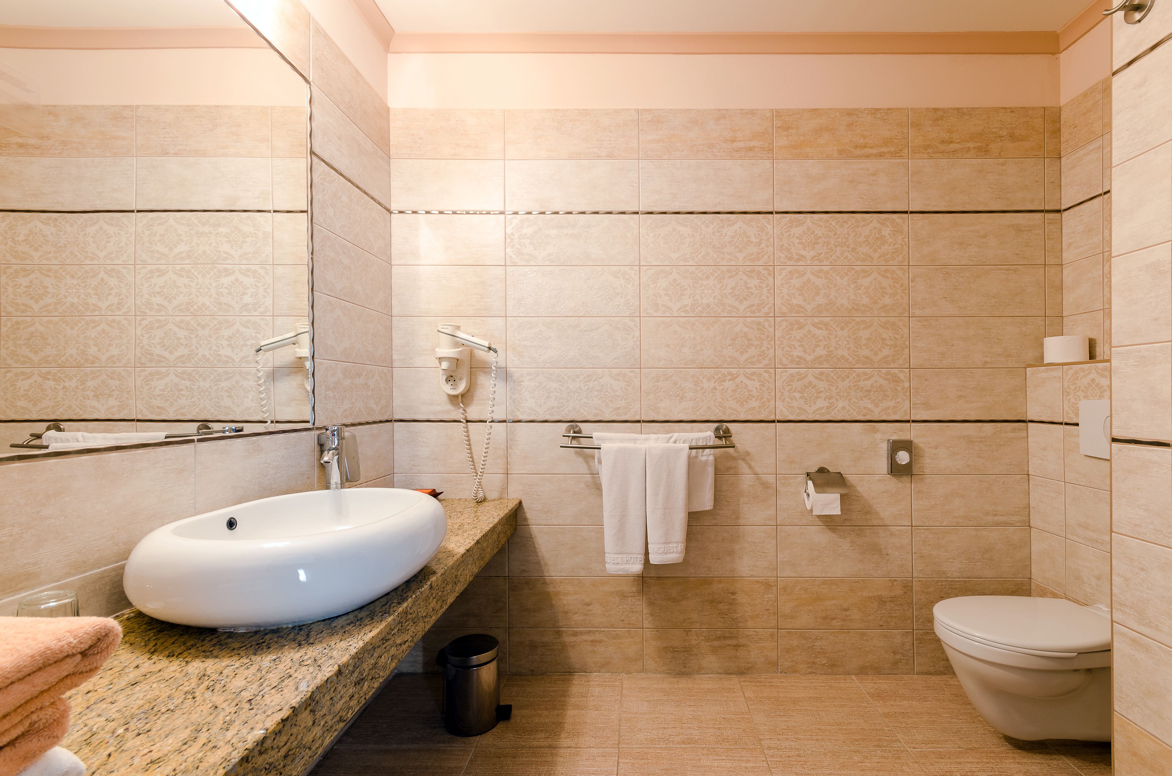 Une salle de bain équipée d’un lavabo, de toilettes et d’un porte-serviettes.