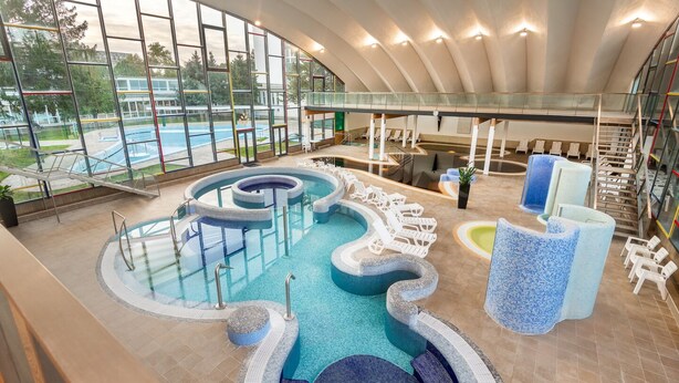 A large indoor swimming pool with multiple lanes and a separate hot tub area. - Hunguest Hotel Apollo (Hajduszoboszlo)