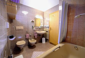 Une salle de bain équipée d’une baignoire, d’un lavabo, d’un bidet et de toilettes.