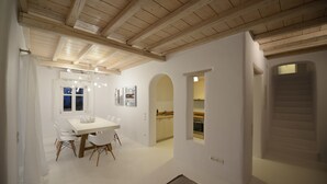 Un interior moderno con comedor, cocina y escalera.