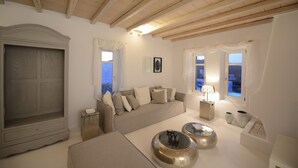 Una sala de estar moderna con un sofá, dos mesas redondas y un aparador.