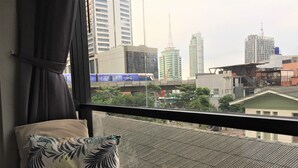 Habitación de hotel con vista a un paisaje urbano, que incluye edificios altos y un puente.