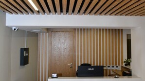 Een receptiebalie met een houten lambrisering, een houten wandpaneel en een modern ontwerp.