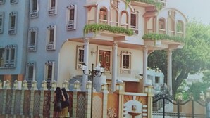 Un edificio de varios pisos con balcones, una cúpula y una puerta.