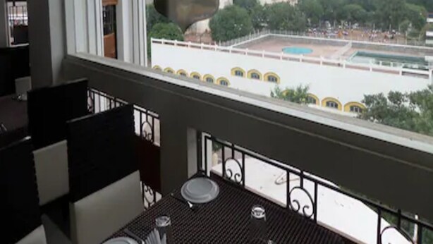 Un restaurante con vista a una plaza y edificios al fondo.