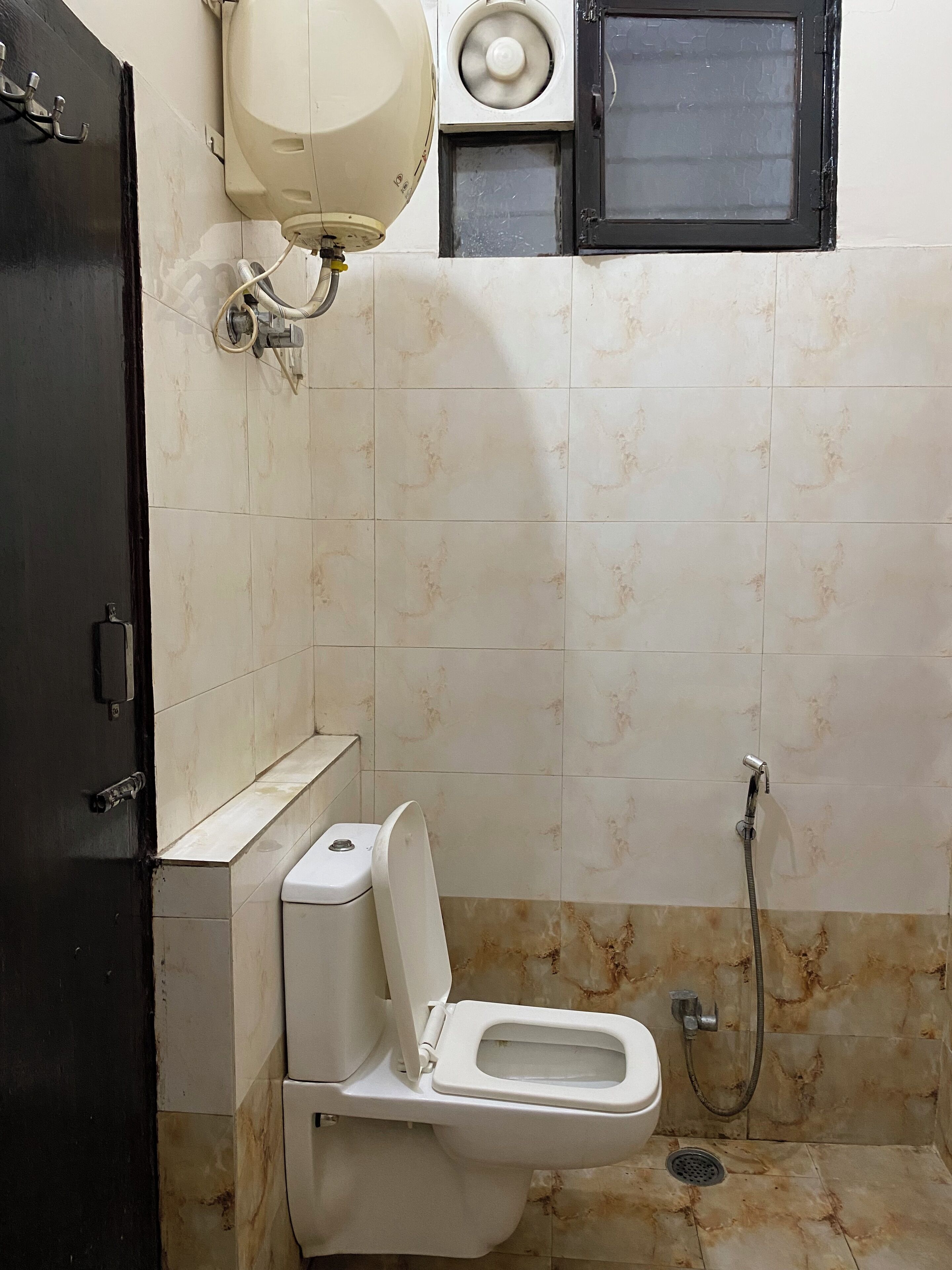 Uma casa de banho pequena com sanita, chuveiro e lavatório.