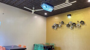 Una habitación con ventilador de techo, candelabro y decoración floral en la pared.