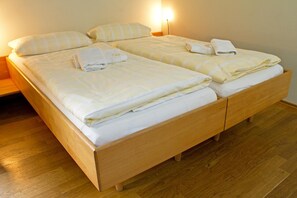 A double bed with two pillows and two sets of folded towels. - Alte Remise (Dresden)