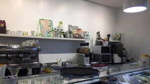 A café with a coffee machine, a display case with pastries, and shelves with various items. - A Casa di Penelope (Rome)