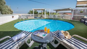 Outdoor pool, open 7 AM to 10 PM, pool umbrellas, pool loungers