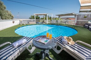 Outdoor pool, open 7 AM to 10 PM, pool umbrellas, pool loungers