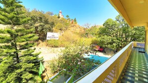 A view of The Jagip House with a sign, a pool, and surrounding trees. - Shri Ganesh Hotel (Abu Road)