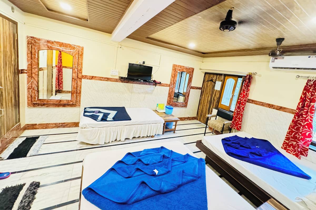 Une chambre avec deux lits, une télévision et une fenêtre avec des rideaux.