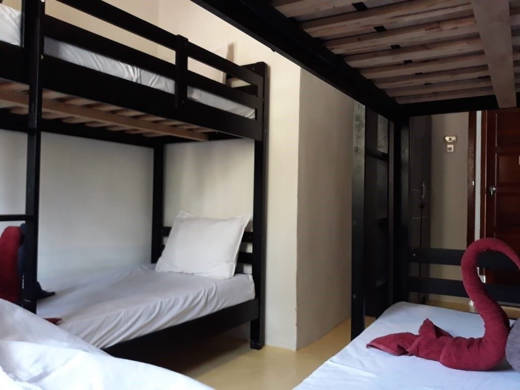 A bunk bed room with a wooden ceiling and a red swan decoration on the lower bunk.