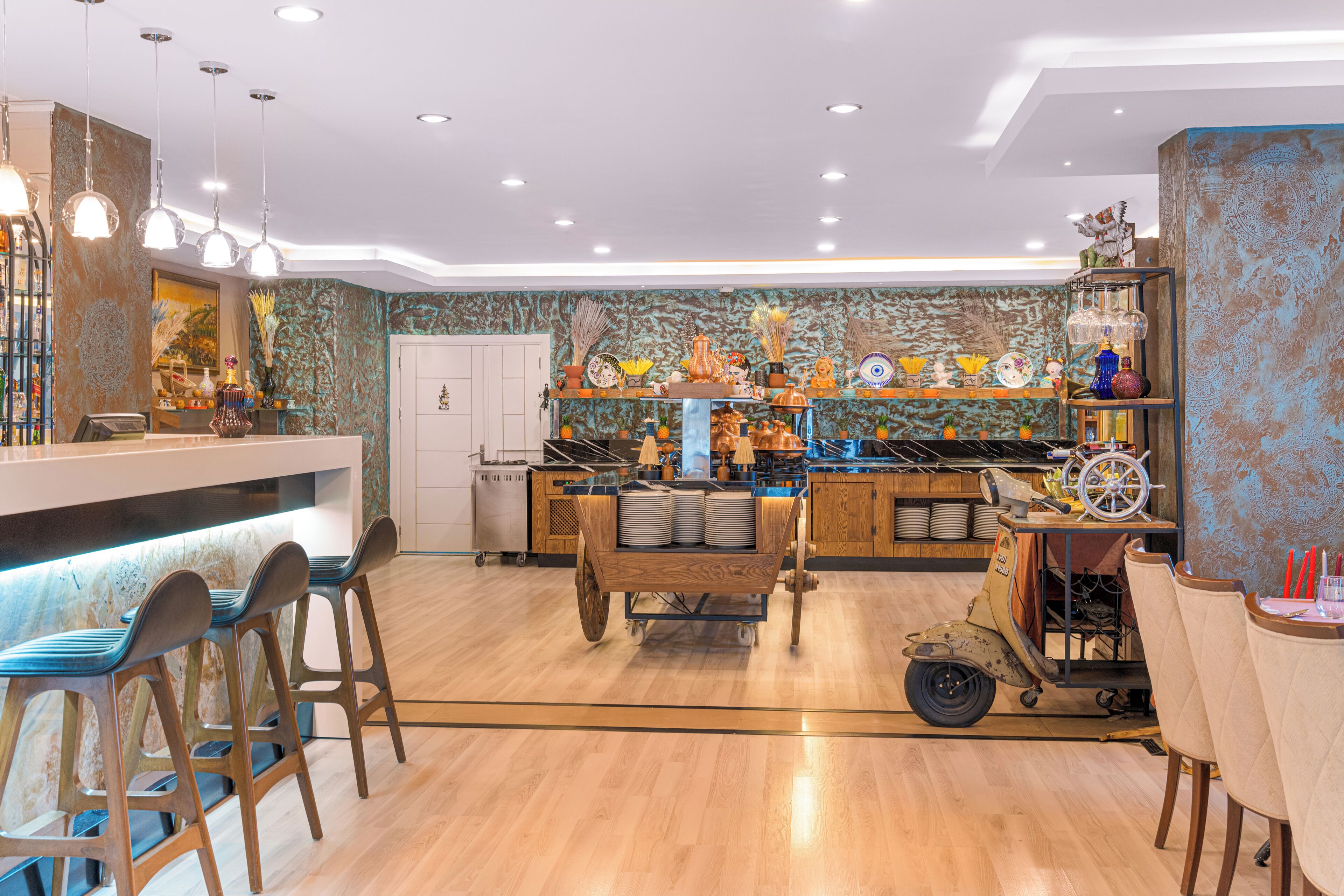 A bar area with stools, a counter, and a vintage cart with plates.