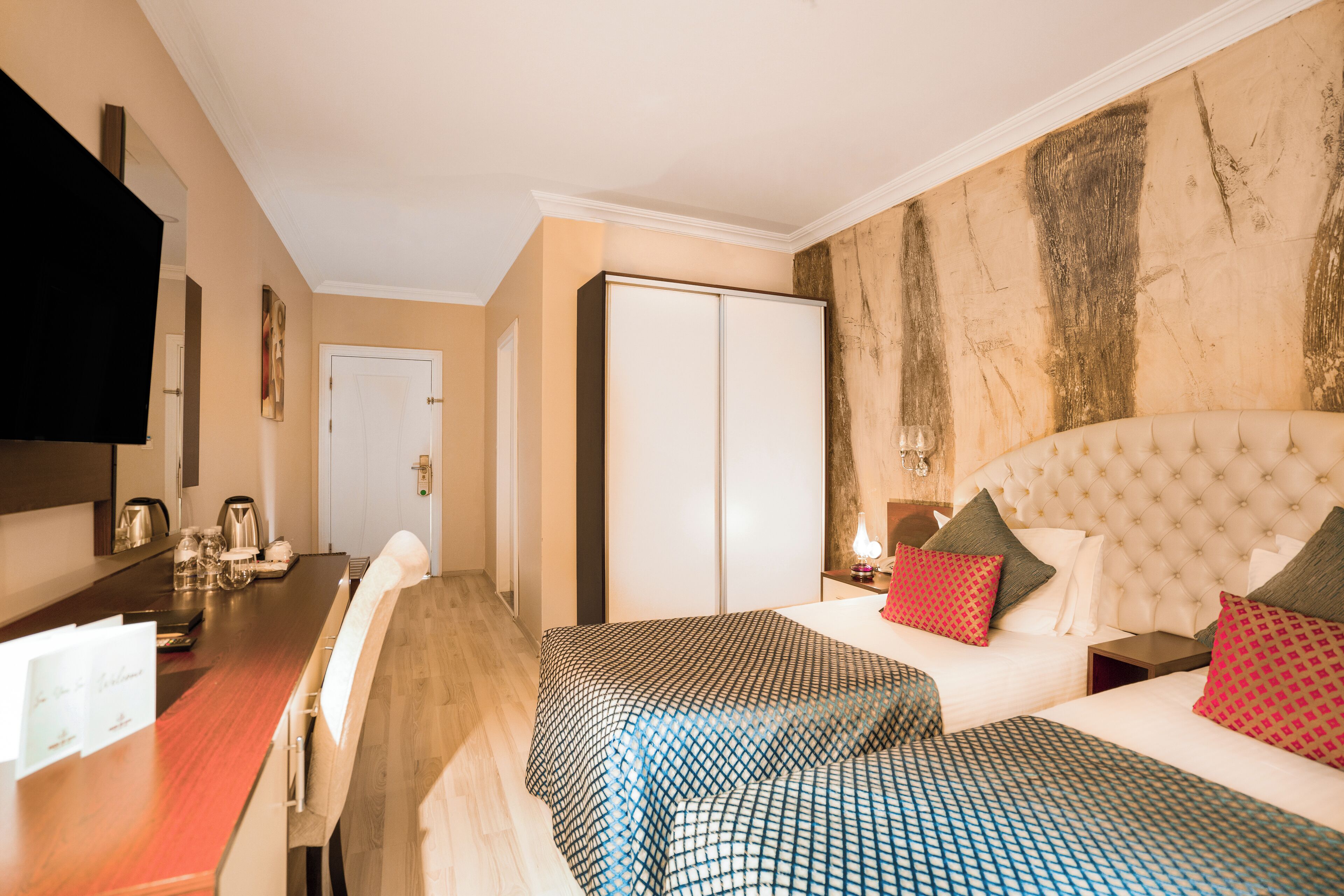 A hotel room with a bed, bedside table, and a television.