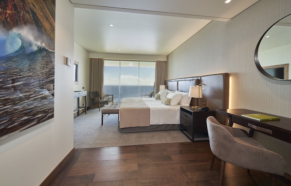 Una habitación de hotel moderna con una cama grande, un escritorio y una silla.