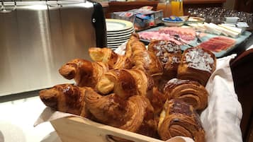 Ein Frühstücksbuffet mit Croissants, Schinken und verschiedenen Fleischsorten.
