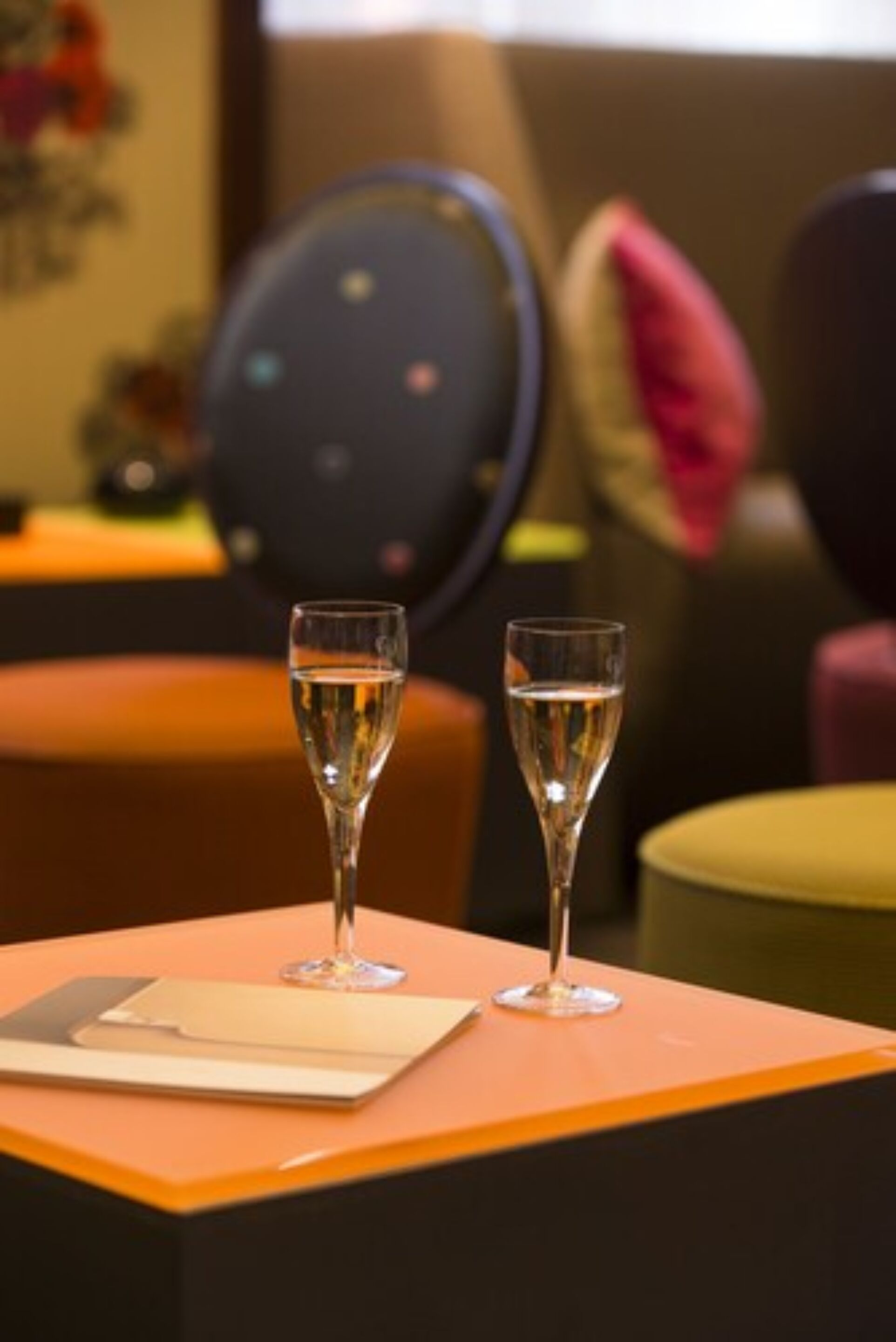 Twee glazen champagne op een tafel met een laptop en een notitieboek.