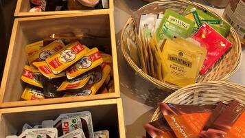 A variety of food items including jars of preserves, packets of chocolate spread, and baskets of tea and snacks.