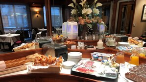 Buffet com diversos alimentos, incluindo doces, carnes e bebidas.
